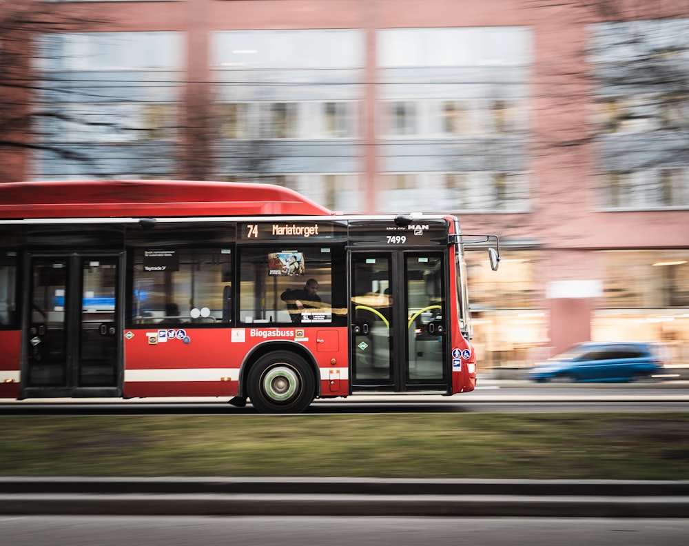 red bus on road during daytime