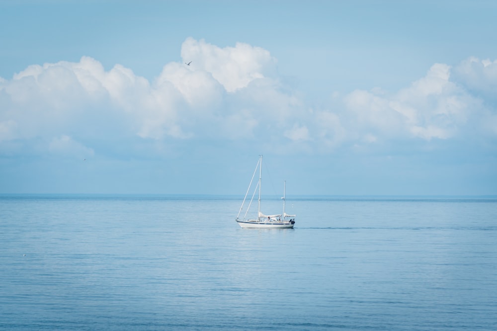 white boat on sea under blue sky during daytime