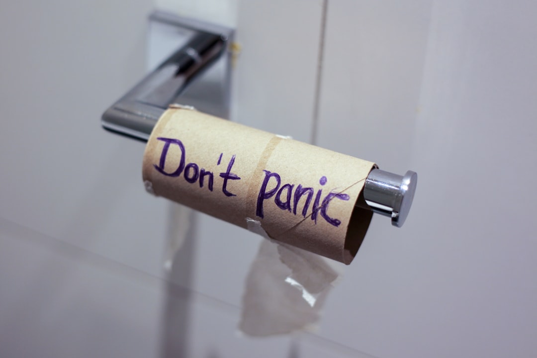 Don't panic written on empty toilet paper roll. 
