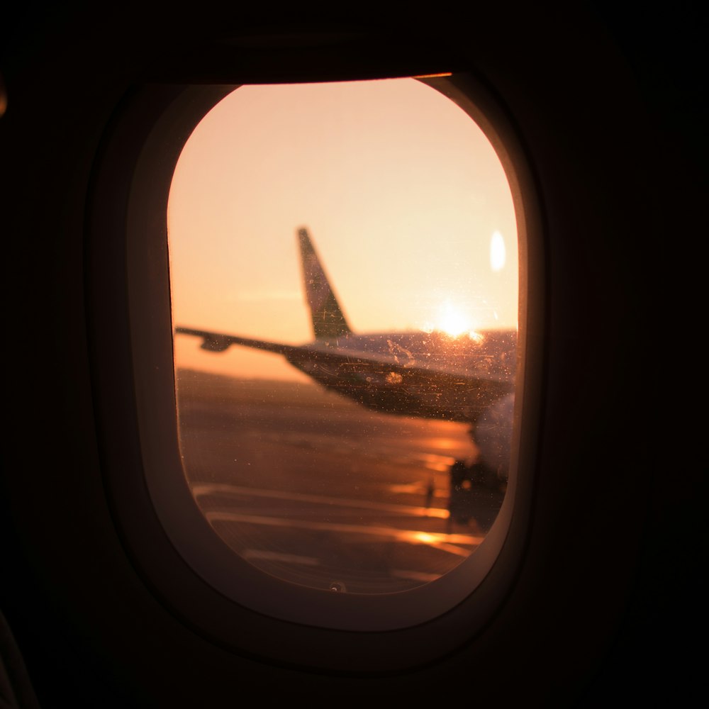 Vue de fenêtre d’avion sur les nuages au coucher du soleil