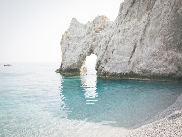 brown rock formation on blue water during daytime