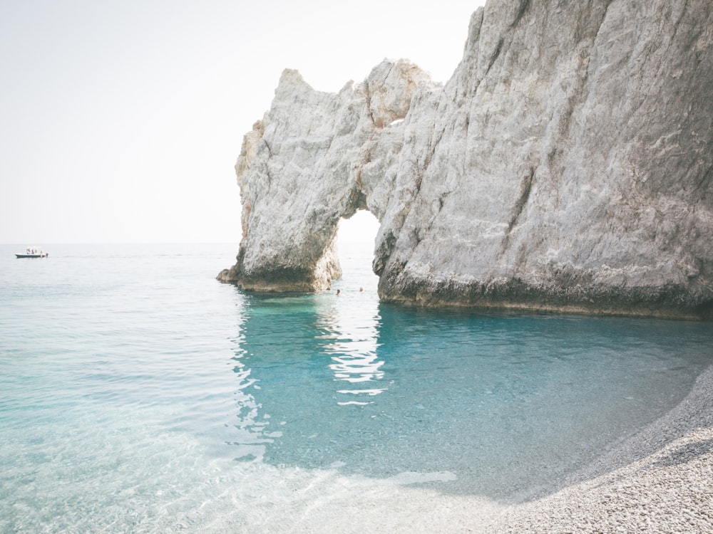 brown rock formation on blue water during daytime