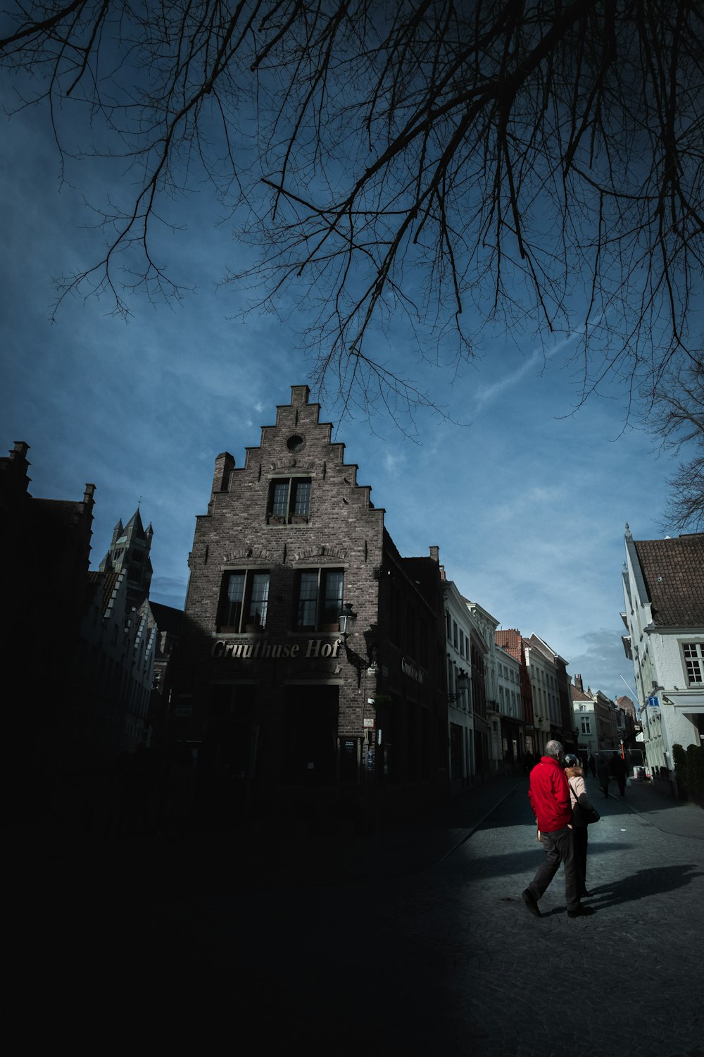 person in red jacket walking on street during daytime