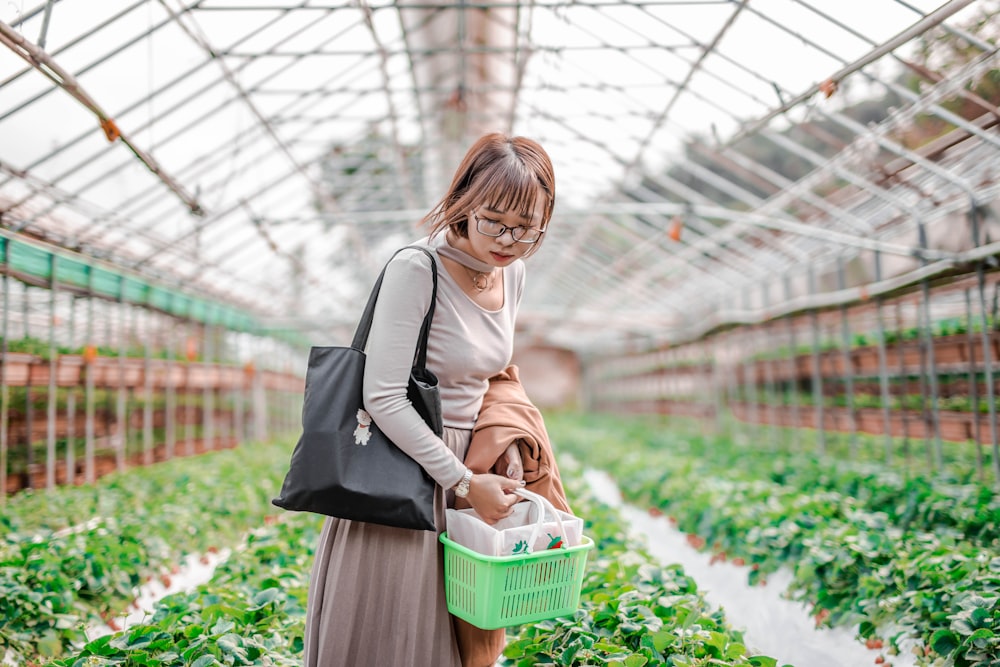 woman in black and white dress carrying green basket