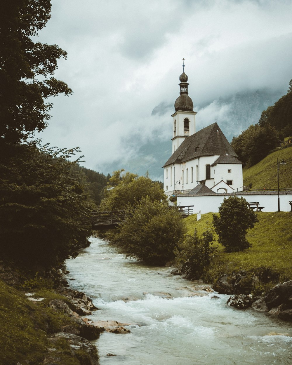 catedral branca e verde perto de árvores verdes e rio durante o dia