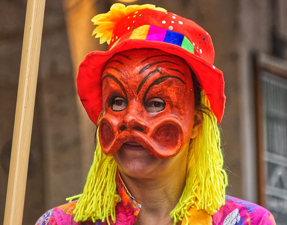 woman in yellow green and red floral shirt wearing red and yellow floral headdress