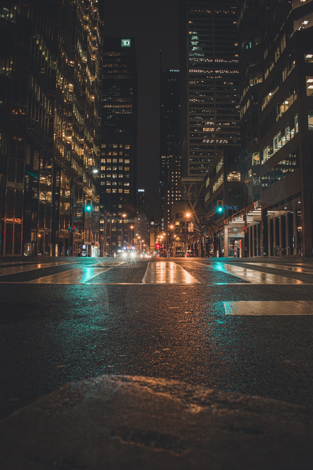 black asphalt road between high rise buildings during night time