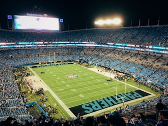 people watching football game during nighttime