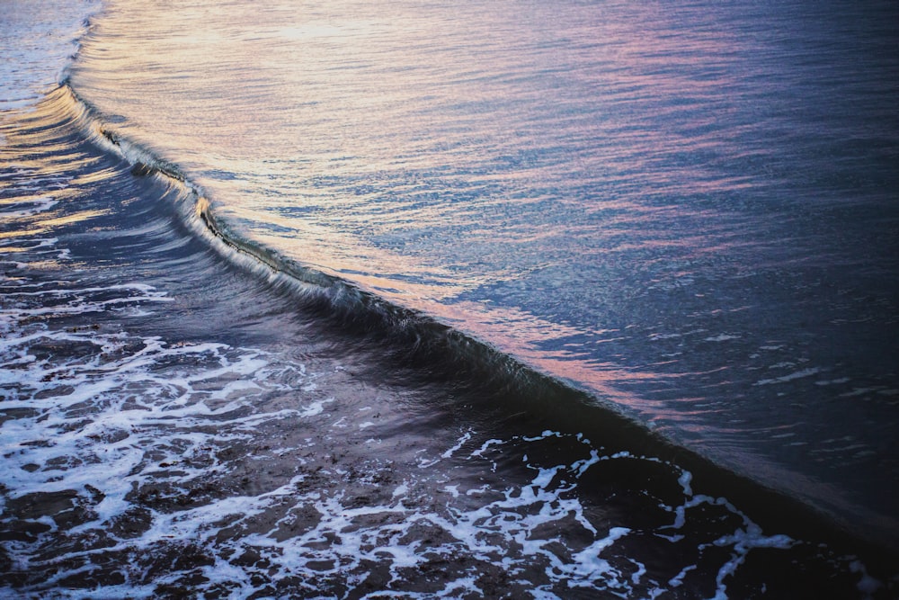 ocean waves crashing on shore during daytime