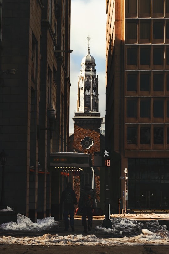 people walking on sidewalk near brown concrete building during daytime in Quebec City Area Canada