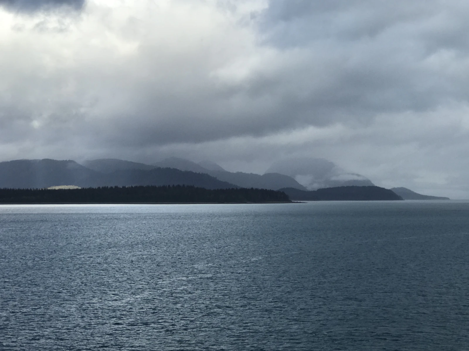 A ship in Glacier Bay, Alaska, beneath snow-capped mountains