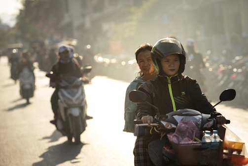 woman in green jacket carrying baby in black jacket