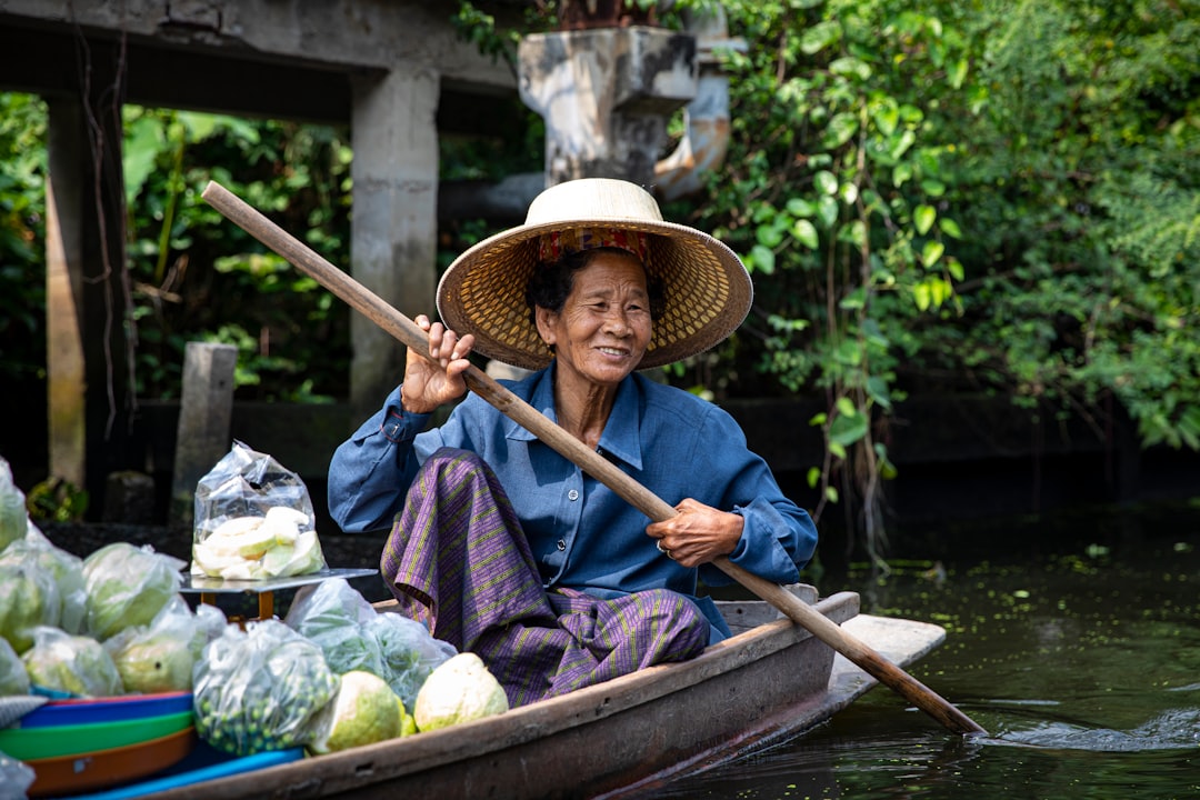 man in blue shirt and brown hat riding on brown boat during daytime