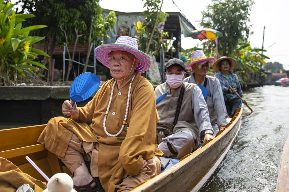 man in brown thobe sitting on boat during daytime