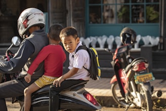 boy in red crew neck t-shirt riding red motorcycle