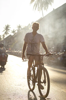 A rider cruising past palm trees on a sunny Marrakech street with the Atlas Mountains in the background.