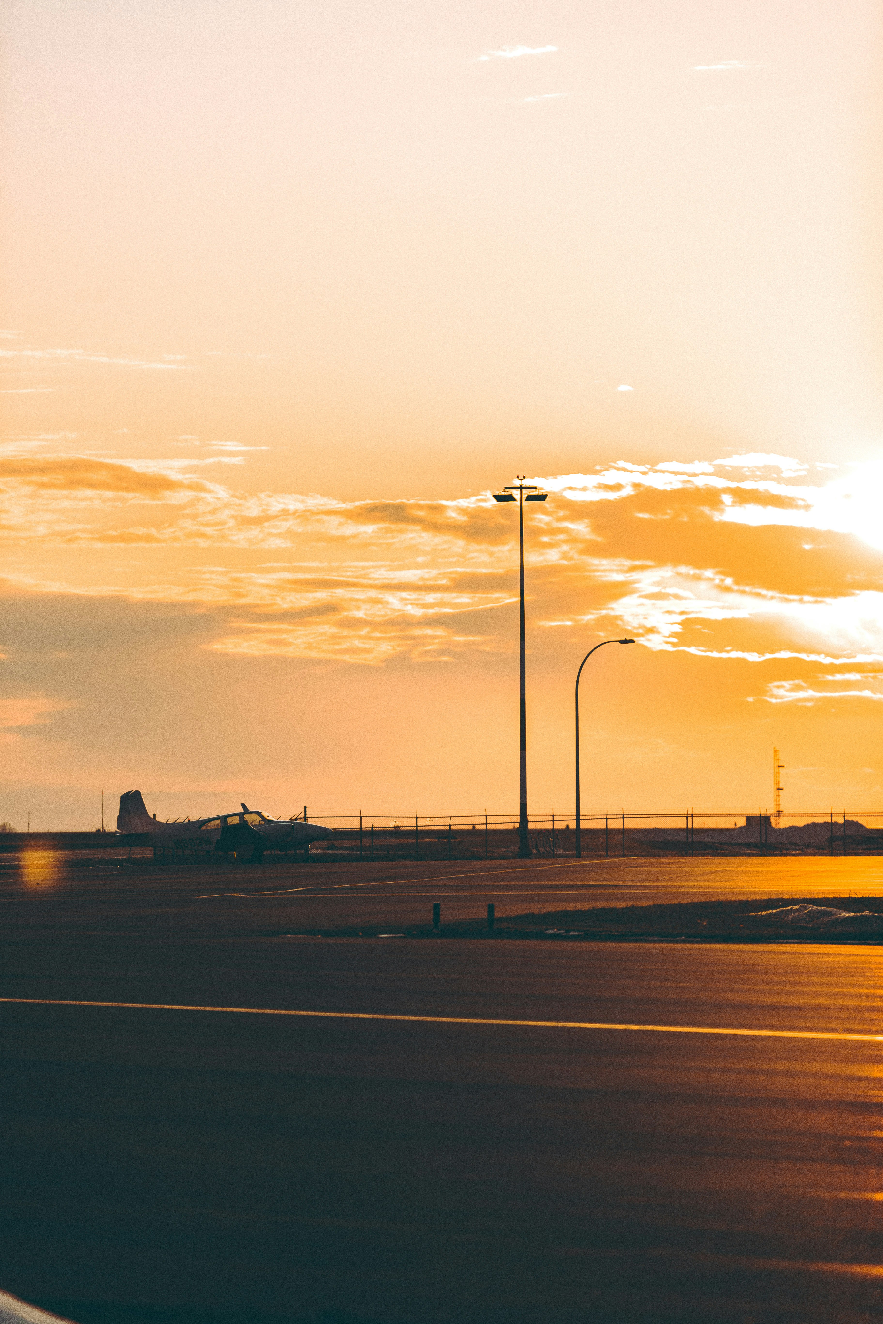 silhouette of airplane on airport during sunset