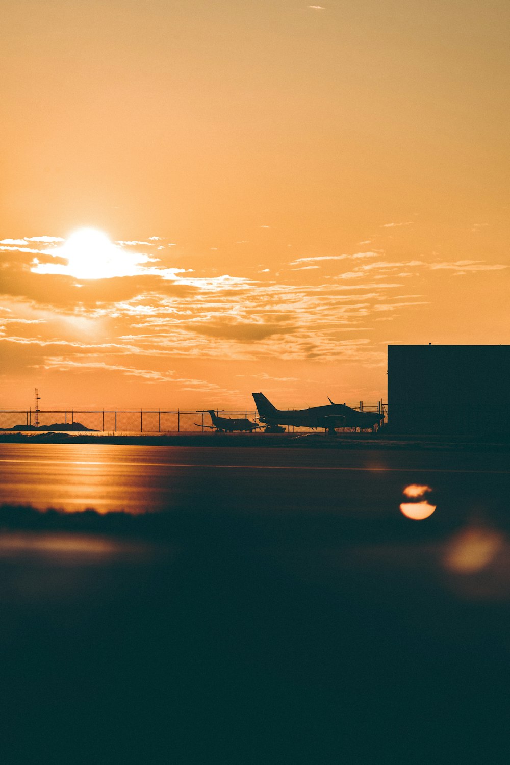 silhouette of airplane on airport during sunset