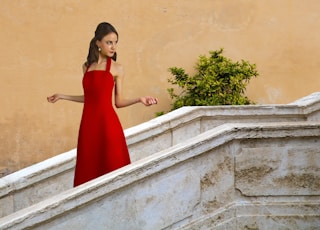 woman in red sleeveless dress standing on stairs