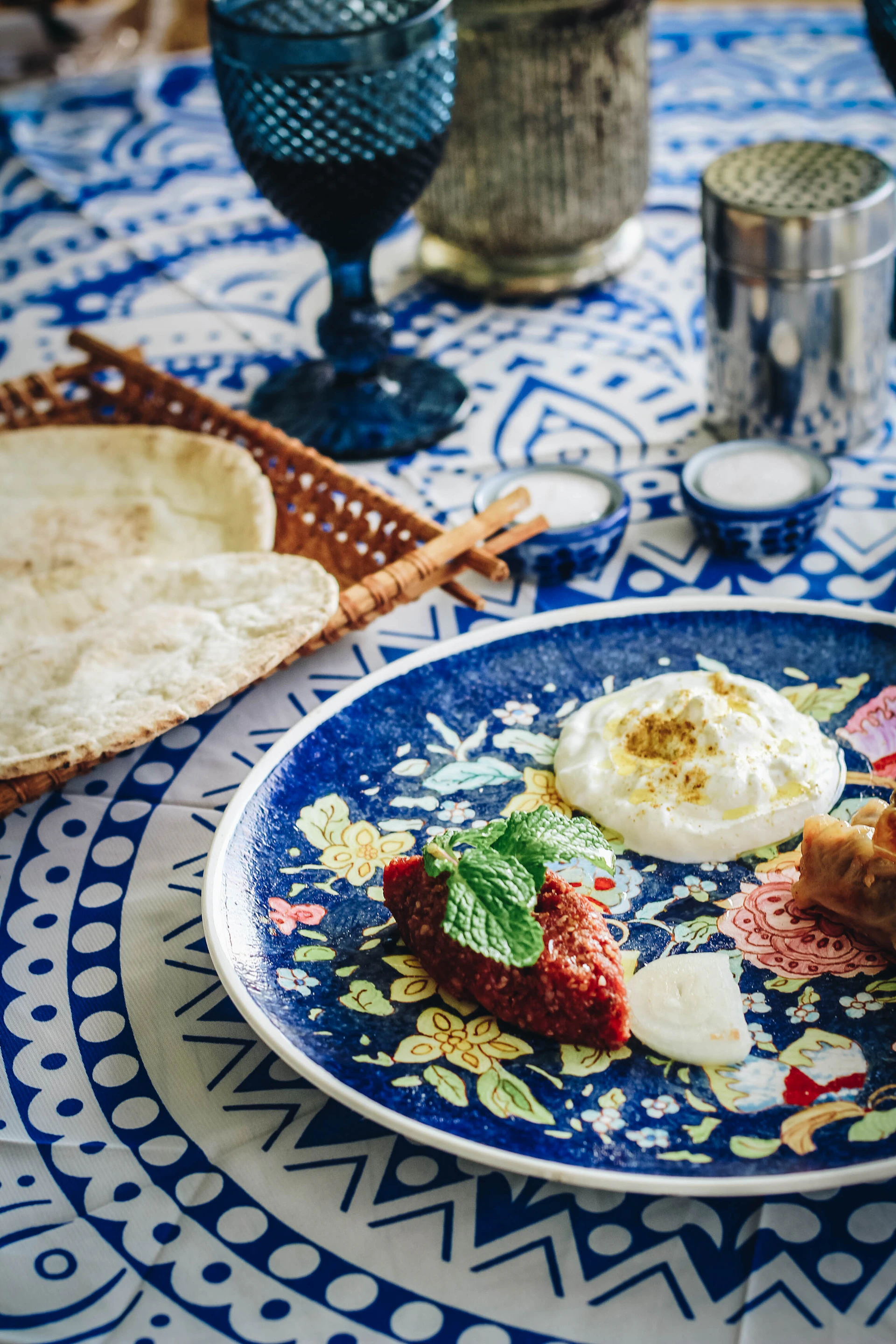 A vibrant spread featuring traditional Egyptian koshari topped with crispy onions, set against a backdrop of papyrus-patterned tablecloth.
