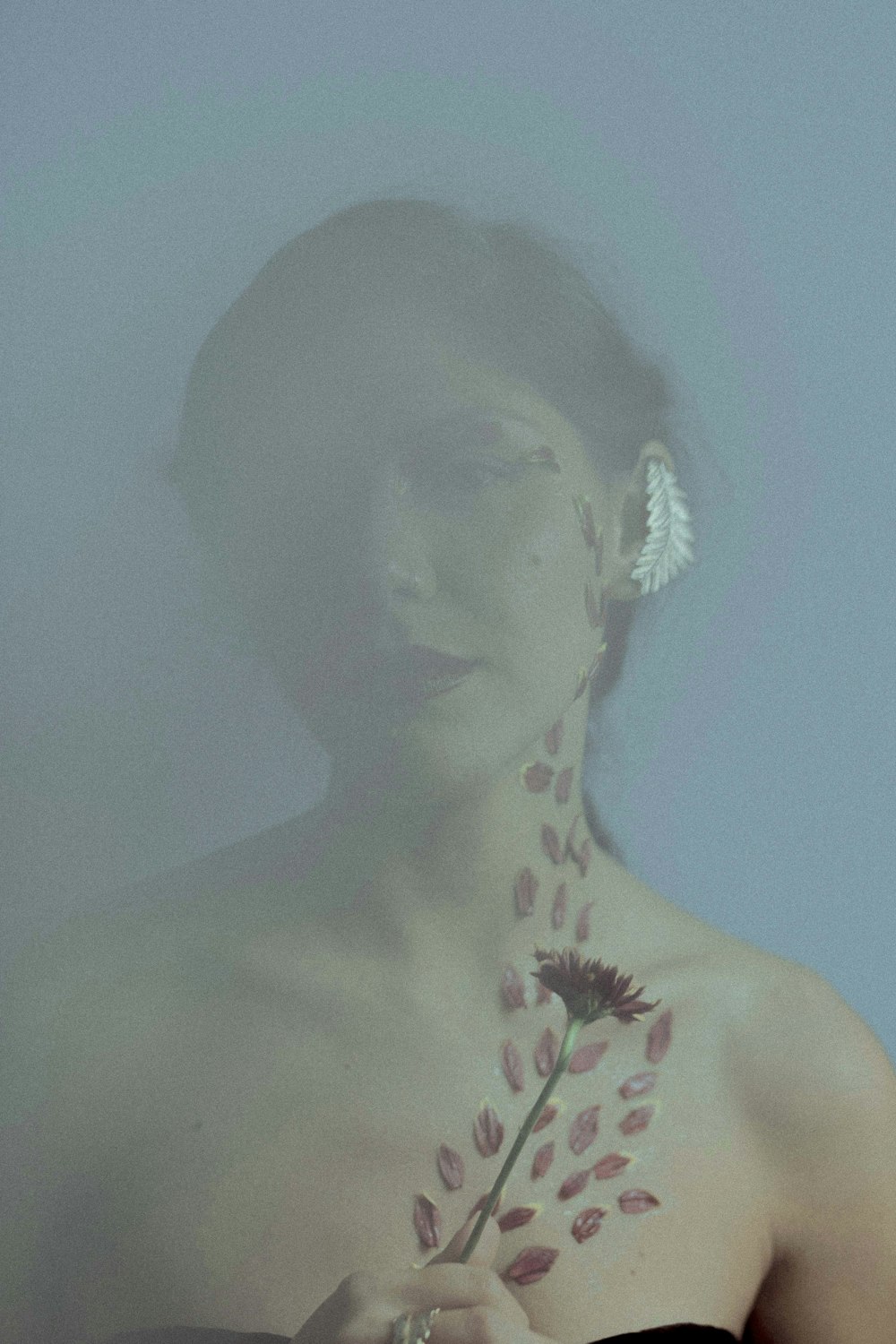 topless woman with pink flower on her ear