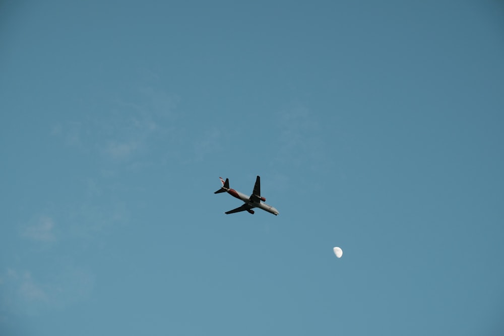 white airplane in mid air during daytime