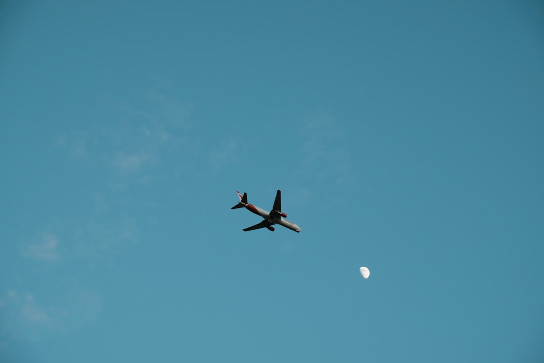 white airplane in mid air during daytime