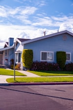 white and gray house near green trees during daytime