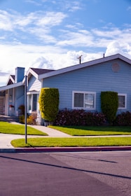 white and gray house near green trees during daytime