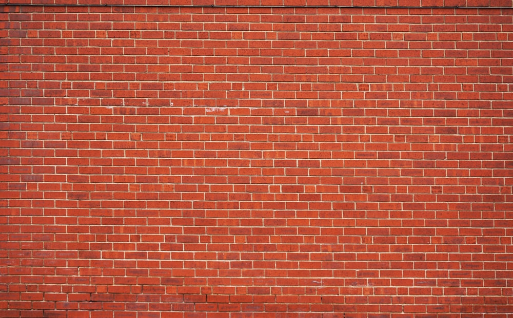 parede de tijolo vermelho durante o dia