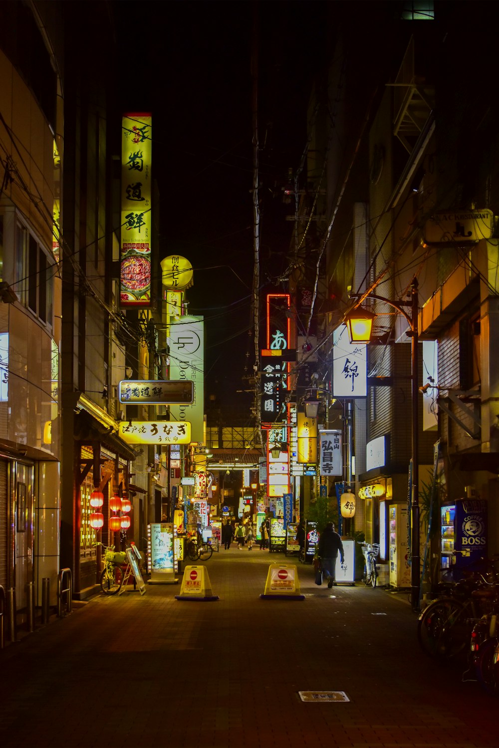 cars on road between buildings during night time