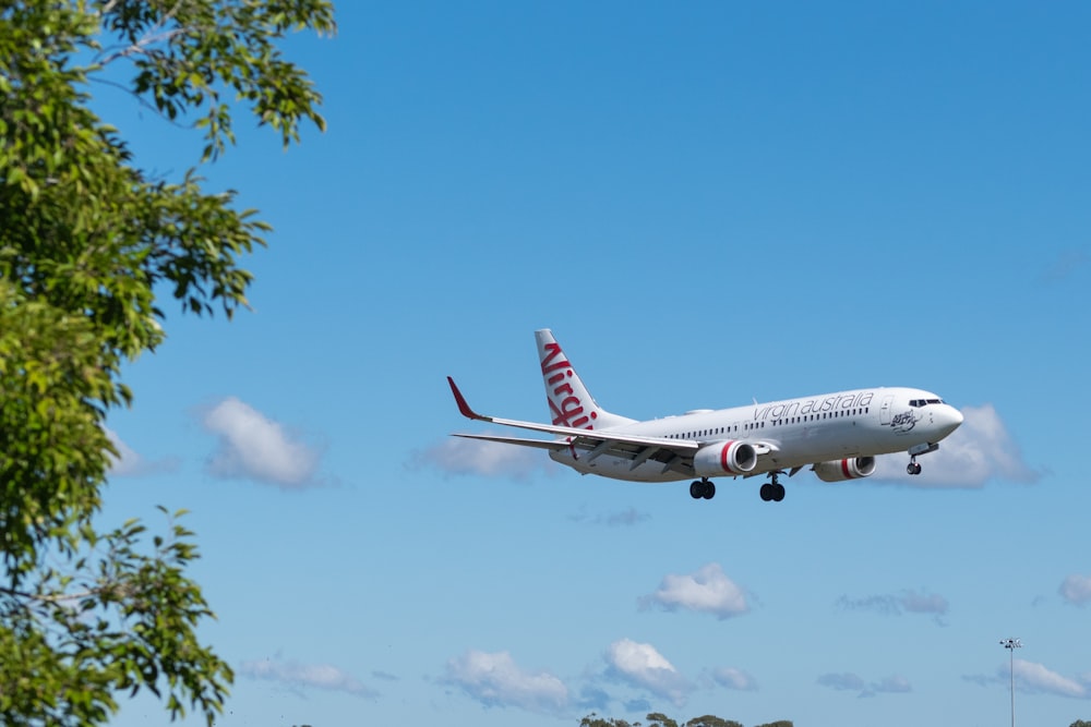 white and red passenger plane in the sky