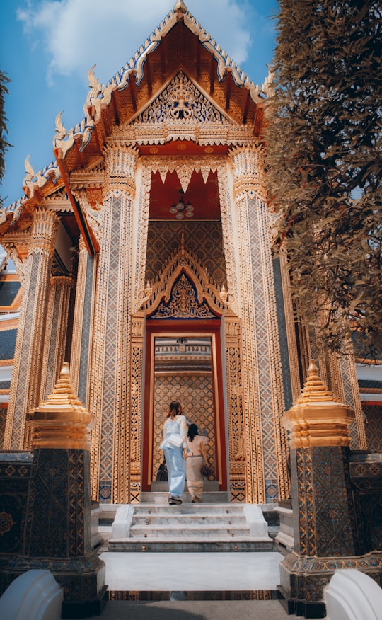 man and woman standing in front of brown concrete building during daytime in Wat Ratchabophit Sathitmahasimaram Ratchaworawihan Thailand
