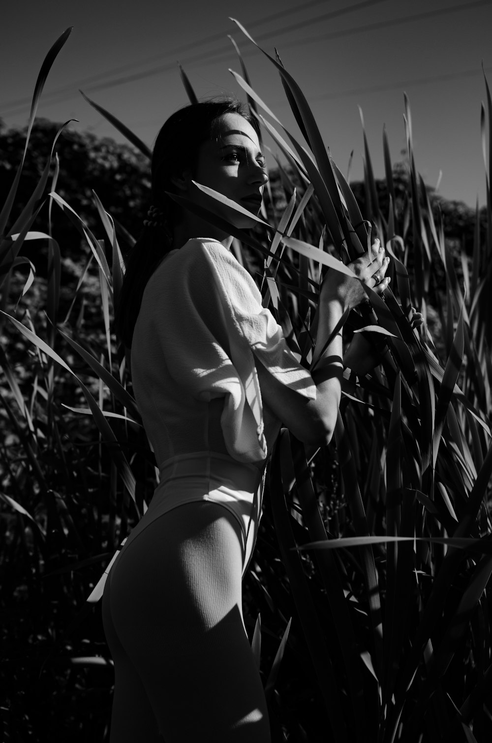 woman in white long sleeve shirt and black panty standing on grass field