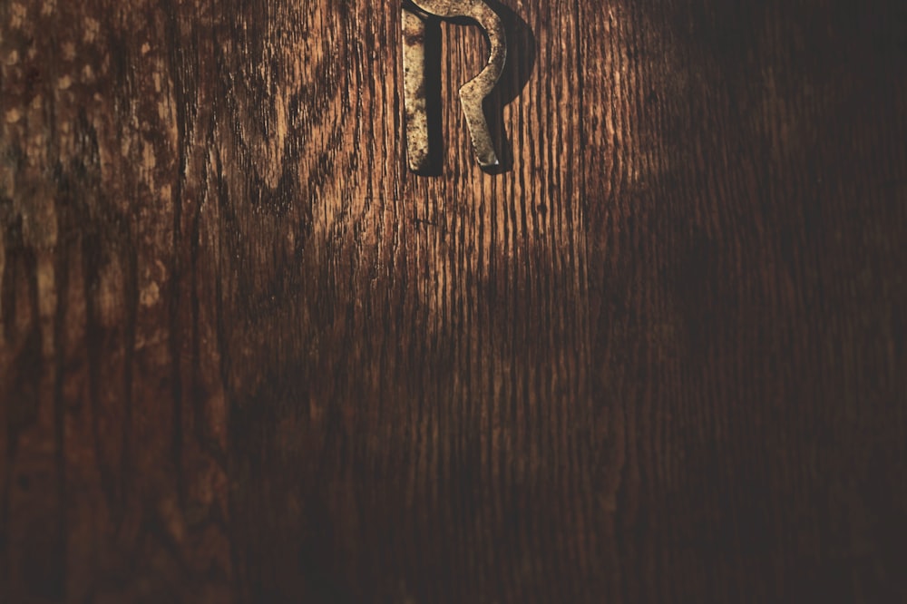 Letra B plateada sobre mesa de madera marrón