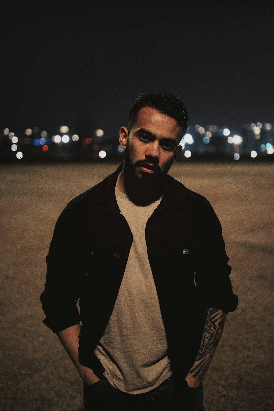 man in black coat standing on field during night time