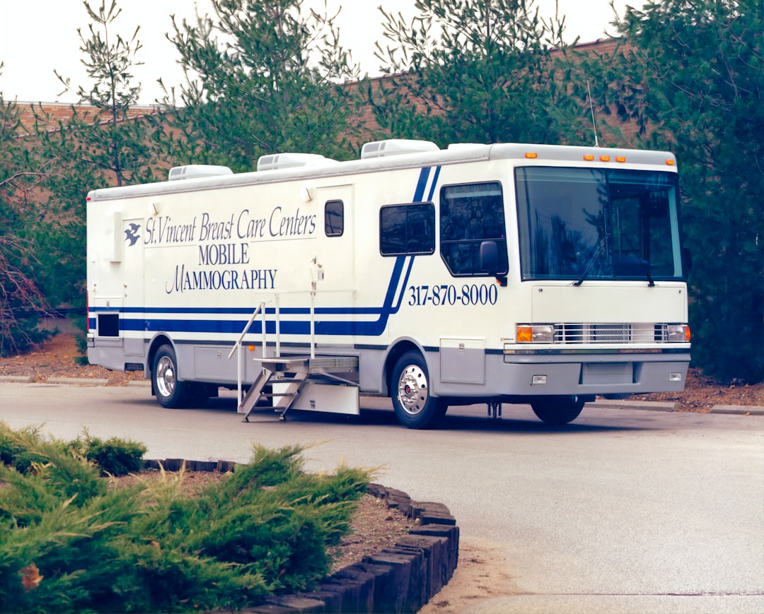 white and blue rv trailer parked on gray asphalt road during daytime