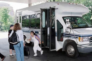 A mother waving goodbye as her child safely enters the school with a sódelas driver.