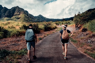 man in blue shirt and black shorts walking on road during daytime