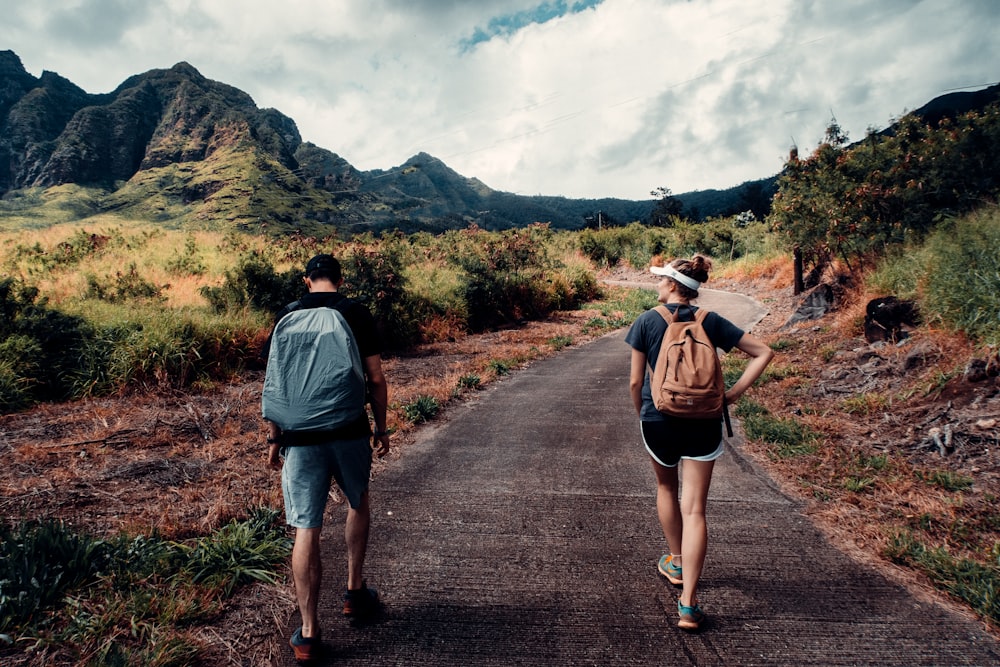 man in blue shirt and black shorts walking on road during daytime