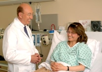 A caring nurse interacting with a patient in a warm and inviting hospital room.