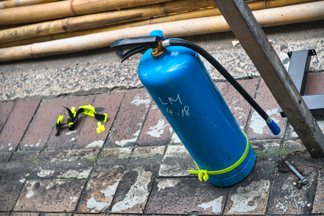 blue fire extinguisher on brown brick floor