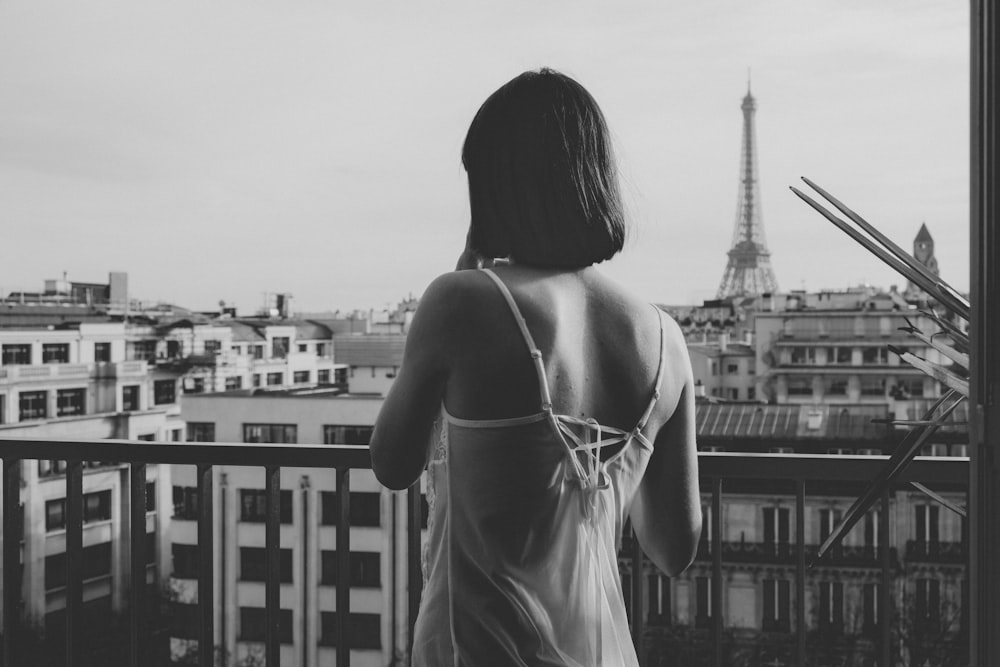 woman in spaghetti strap top standing in front of building