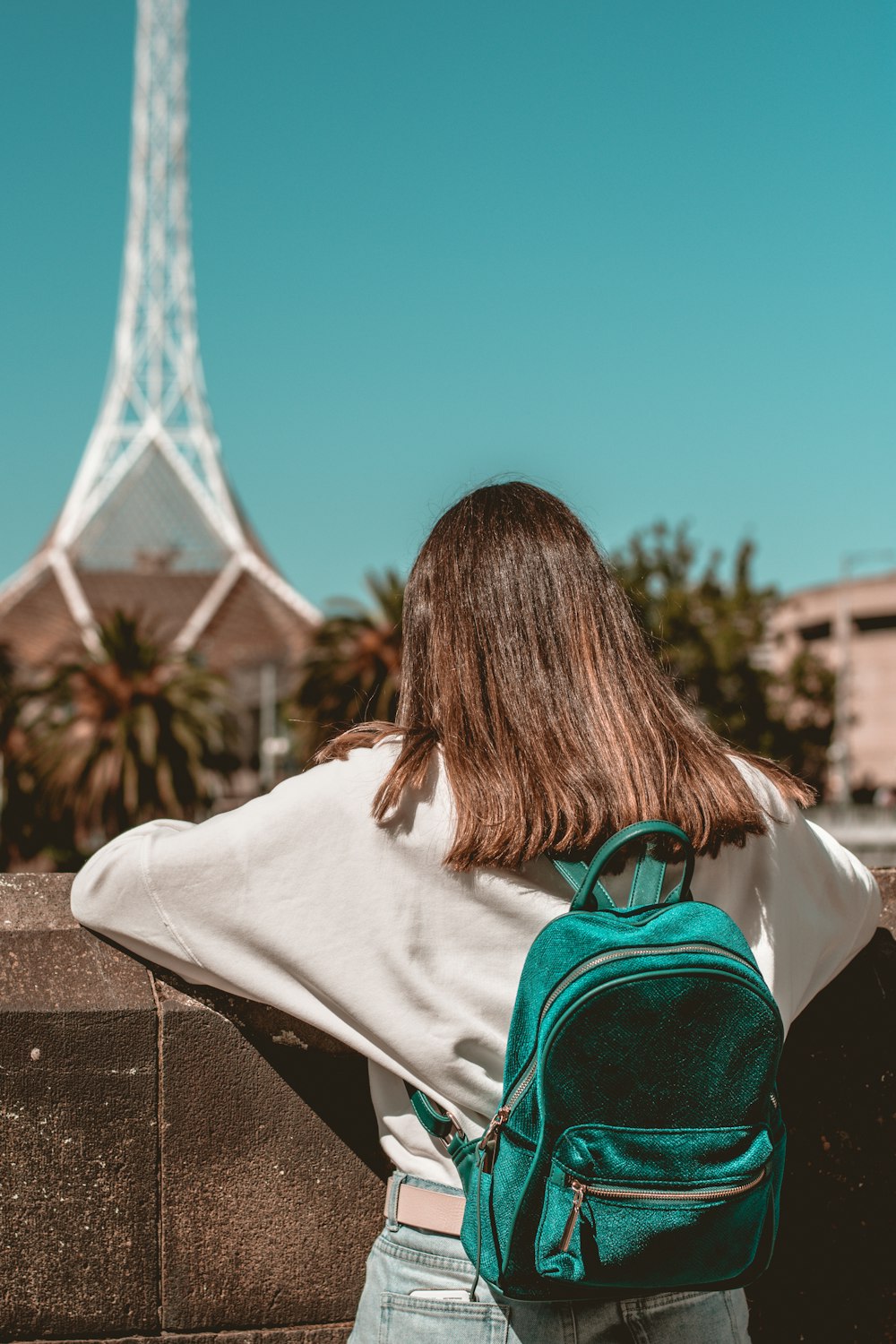 woman in white shirt sitting on concrete bench during daytime