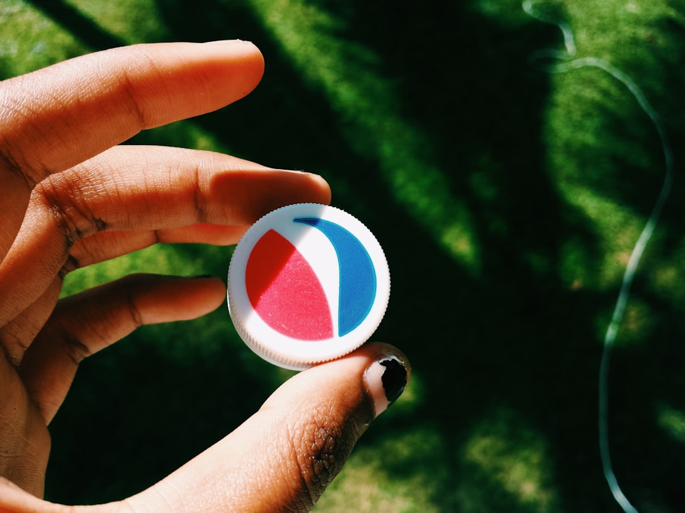 person holding blue and white round ornament