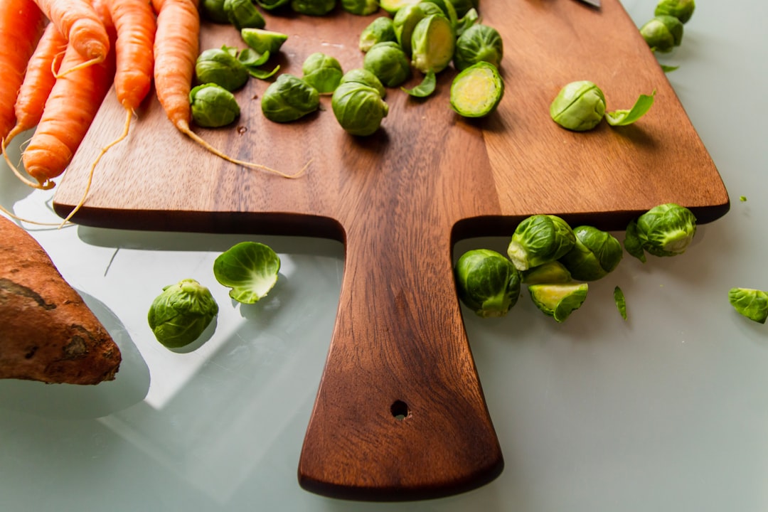 green and orange vegetables on brown wooden chopping board