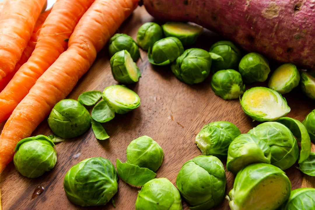 carrots and green leaves on brown wooden table