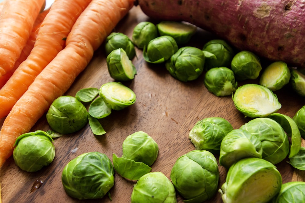 carrots and green leaves on brown wooden table