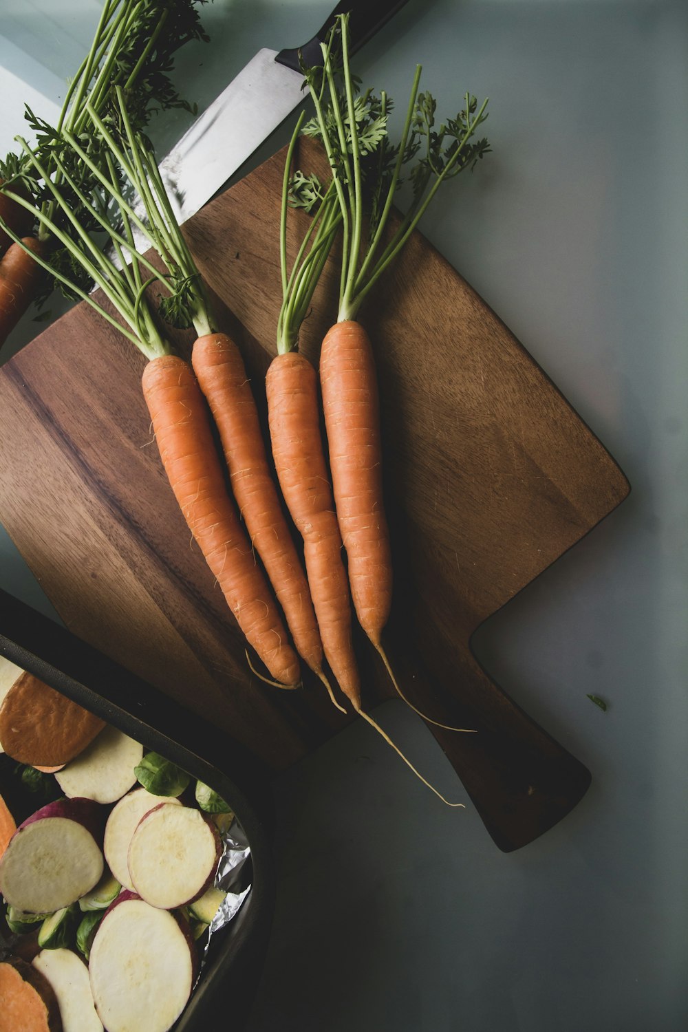 carottes sur une planche à découper à côté d’une planche à découper