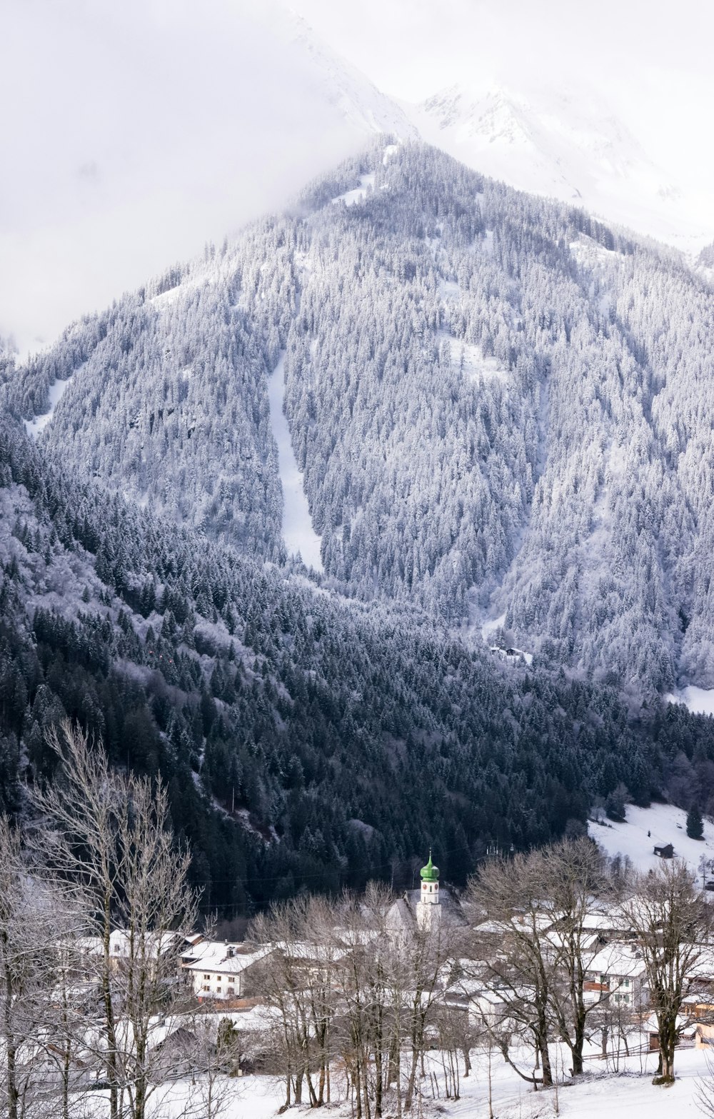 person standing on snow covered ground near mountain during daytime